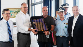 Andreas Dracopoulos, President of the Stavros Niarchos Foundation, standing with the Minister of Citizen Protection, Takis Theodoricakos, the Chief of the Greek Police, Major General Konstantinos Skumas and other members of the Greek Police, holding a gift of honor